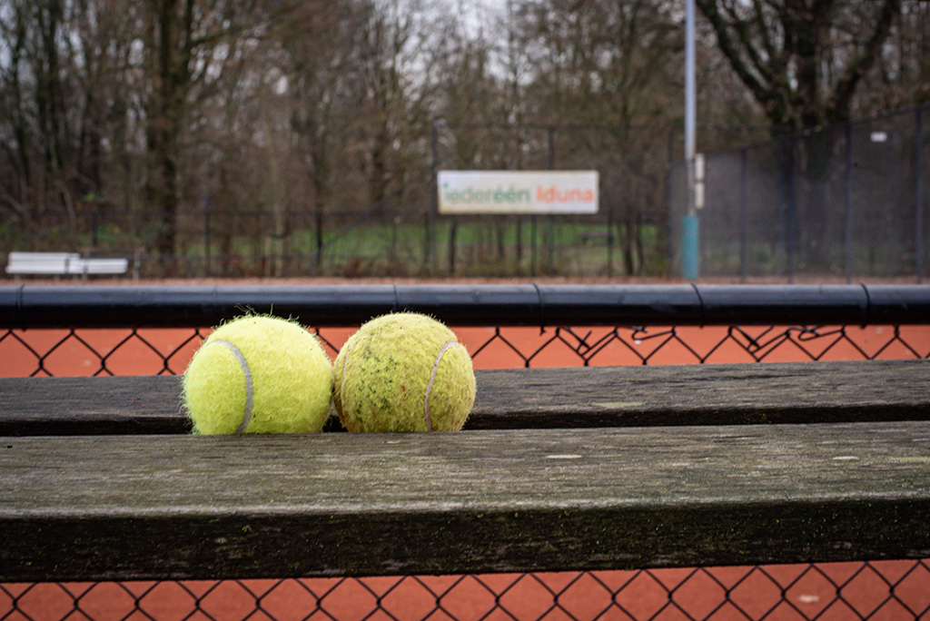 tennisballen bij een tennisveld
