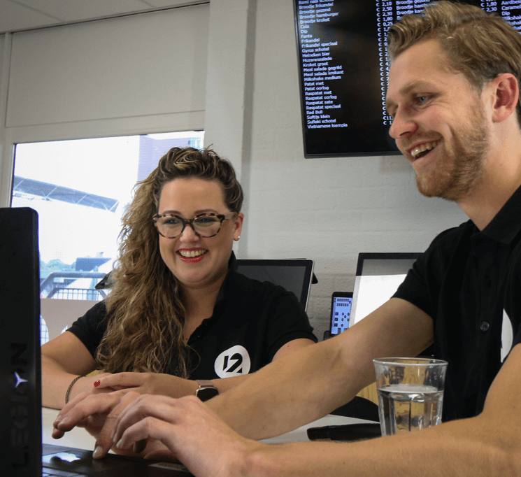 lachende personen achter laptop